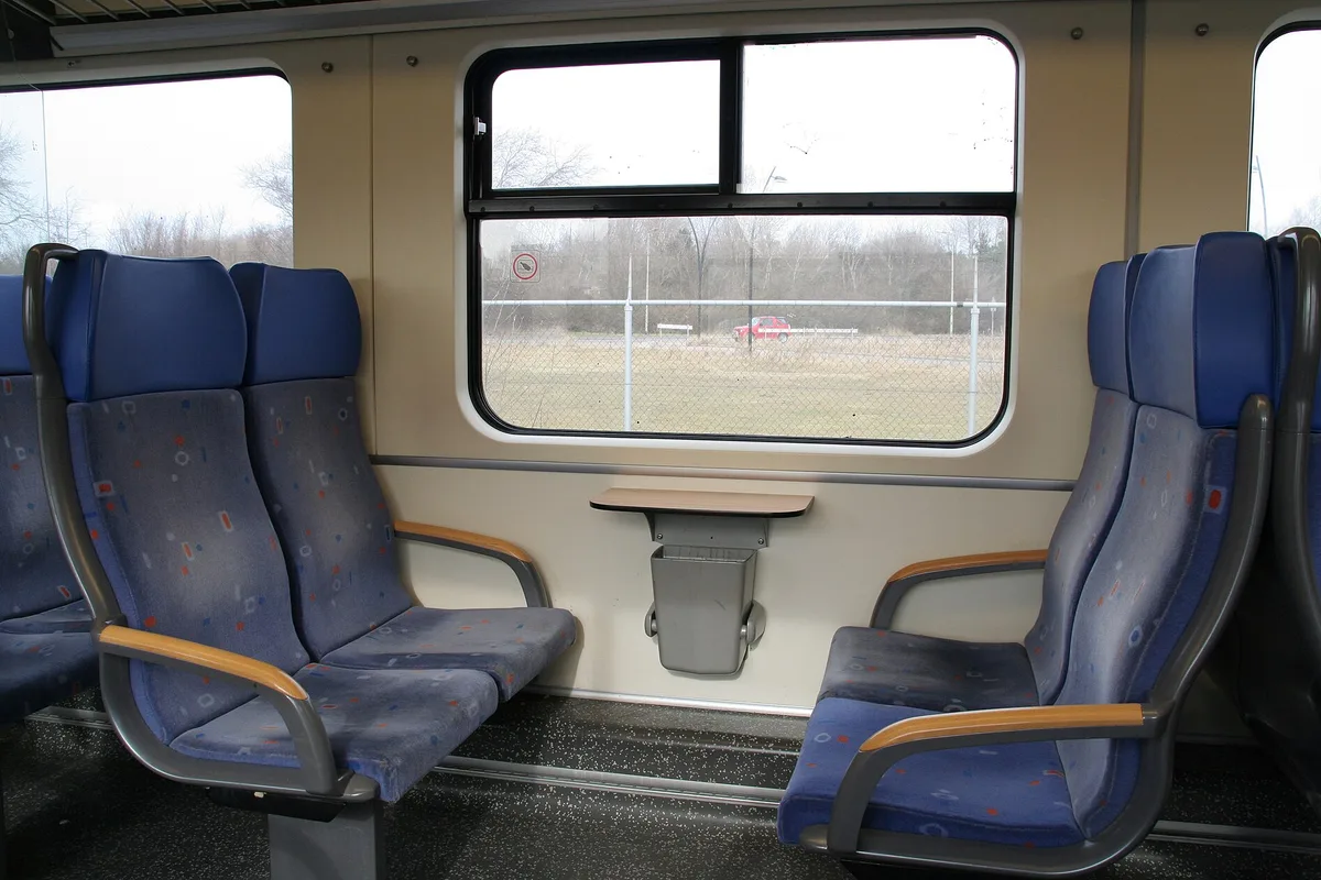 Lege rijen blauwe stoelen in de tweede klas van een Nederlandse Sprinter-trein
