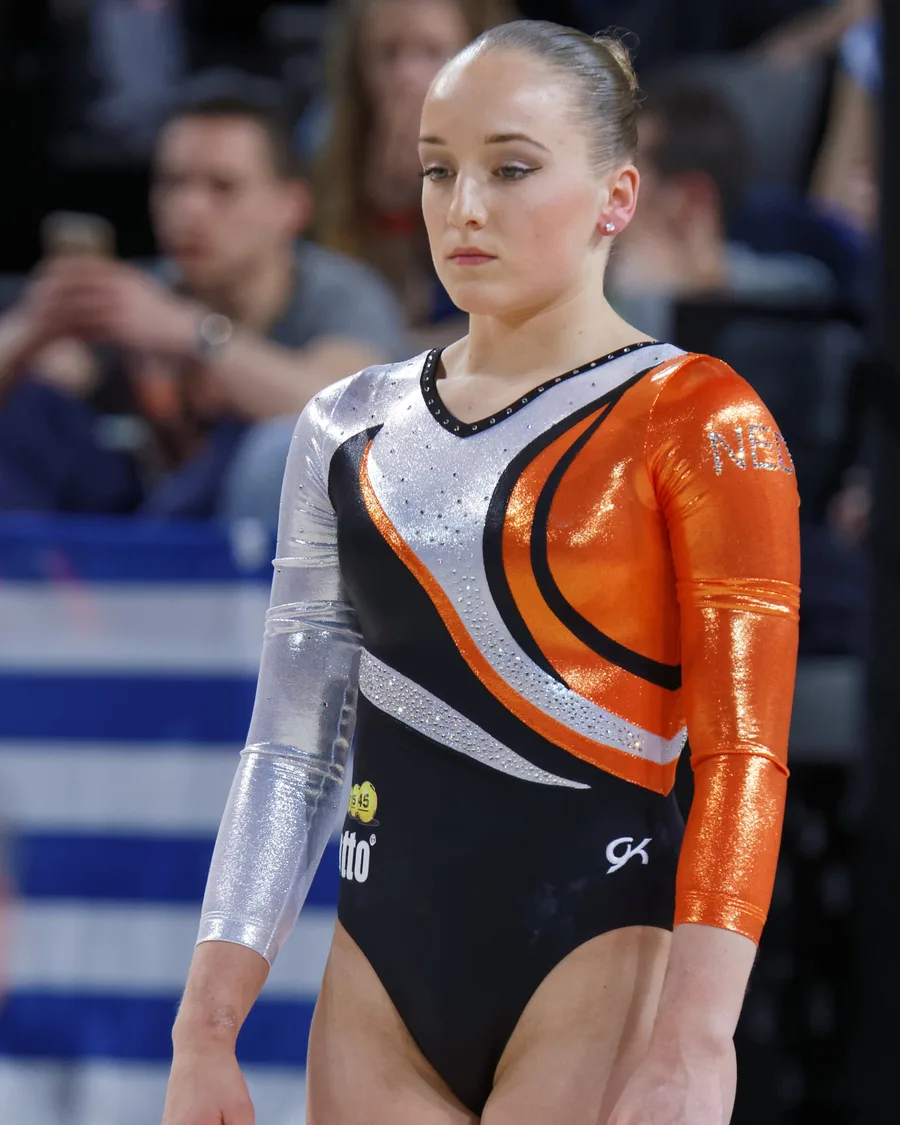 Sanne Wevers in een oranje turnpakje bij de balk tijdens het EK turnen van 2015